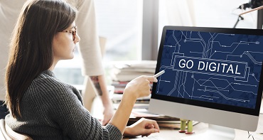 Woman in front of computer monitor point at the screen with legeng: Go Digital