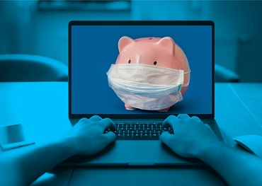 Two hands typing on a laptop and a piggy bank with mask on laptop screen