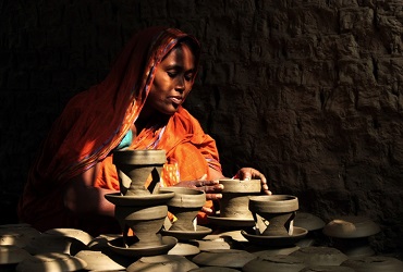 An entrepreneur in Bangladesh puts the finishing touches on her clay pots. Photo: Moksumul Haque, 2015 CGAP Photo Contest