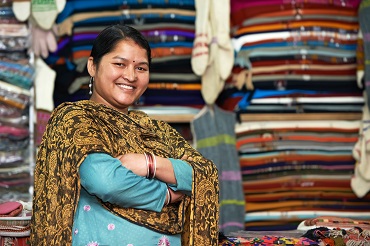 Indian woman smiling in front of a clothing store
