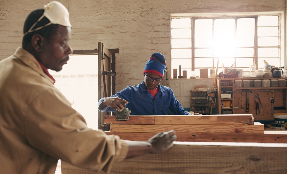 African man with a mask working a workshop