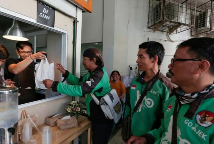 Go-Jek drivers wait for orders at a coffee stall in Jakarta- The app has become much more than a ride hailer -Credit Reuters