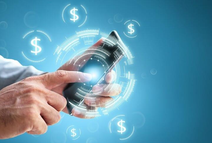 Business man hand holding a phone with currency signs on blue background