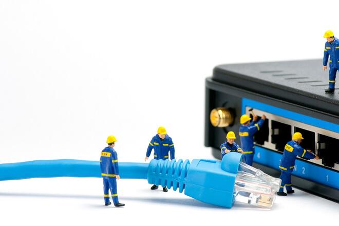 Back of a modem with small worker figures connecting a big blue cable