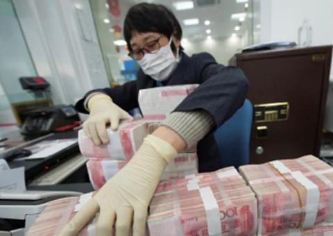 A bank employee wearing a mask arranges stacks of Chinese yuan notes at a bank in Nantong, Jiangsu province, China on Jan 30, 2020.PHOTO: REUTERS A bank employee wearing a mask arranges stacks of Chinese yuan notes at a bank in Nantong, Jiangsu province, China on Jan 30, 2020.PHOTO: REUTERS