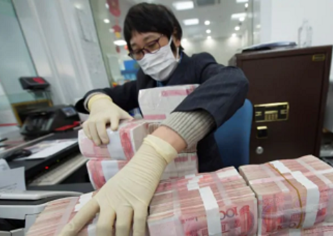 A bank employee wearing a mask arranges stacks of Chinese yuan notes at a bank in Nantong, Jiangsu province, China on Jan 30, 2020.PHOTO: REUTERS