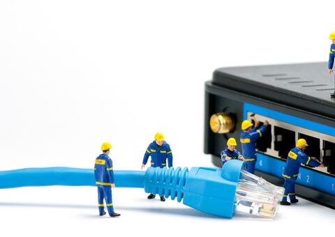 Back of a modem with small worker figures connecting a big blue cable